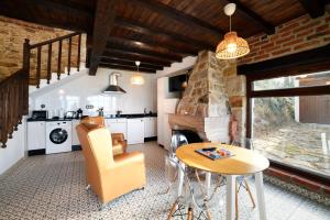 a kitchen with a table and a stone fireplace at Apartamentos La Cabaña del Cerro Alto in Beceña
