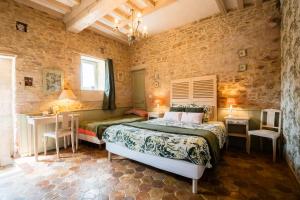a bedroom with two beds and a table and chairs at Le chant des oiseaux in Ryes
