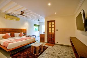 a bedroom with a bed and a flat screen tv at Bliss By Stays,Calangute in Calangute +55 photos