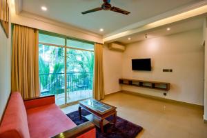 a living room with a couch and a tv at Bliss By Stays,Calangute in Calangute