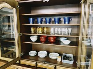 a hutch filled with bowls and plates and blue vases at 直島古民家一棟貸し笑くんNaoshima 'Shoukun' Entire house in Naoshima