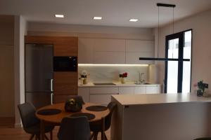 a kitchen with a table and chairs and a refrigerator at OE concept in Guernica y Luno