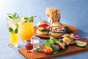 two plates of food with hamburgers and fries and drinks at Okinawa Harborview Hotel in Naha