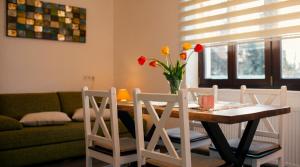a living room with a table with a vase of flowers at Tivoli Apartament in Sebeş
