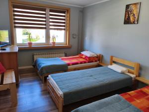 a room with three beds and a window at Apartament Przy Puszczy Białowieskiej in Hajnówka