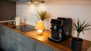 a kitchen counter with a coffee maker and a lamp at Tivoli Apartament in Sebeş +10 photos
