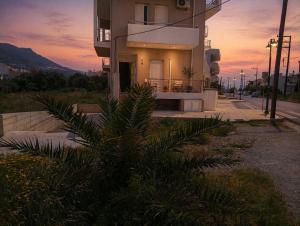 a house with a palm tree in front of a building at Memories Studio in Neapoli Voion