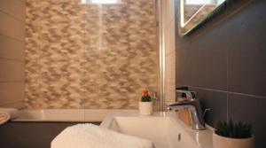 a bathroom with a sink and a shower at Tivoli Apartament in Sebeş