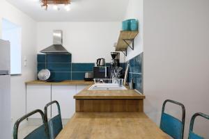 a kitchen with a sink and a table with chairs at Gite des Hauts Grève - Penty in Saint-Michel-en-Grève