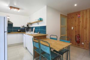 a kitchen with a wooden table and chairs at Gite des Hauts Grève - Penty in Saint-Michel-en-Grève +12 photos