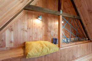 a room in a wooden cabin with a yellow pillow at Gite des Hauts Grève - Penty in Saint-Michel-en-Grève
