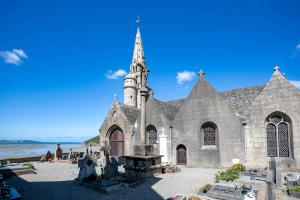 a large stone church with a tower on the beach at Gite des Hauts Grève - Penty in Saint-Michel-en-Grève
