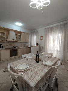 a kitchen with a table with plates and a bottle of wine at Casa Spartaco in Certaldo +7 photos