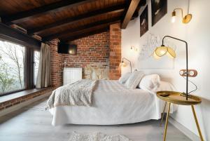 a bedroom with a white bed and a brick wall at Apartamentos La Cabaña del Cerro Alto in Beceña