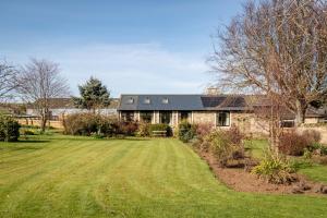 a house with a large lawn in front of it at Easter Kincaple Garden Cottage in St. Andrews