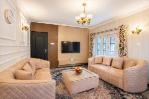 a living room with two couches and a tv at Dar-e-Shafi in Srinagar