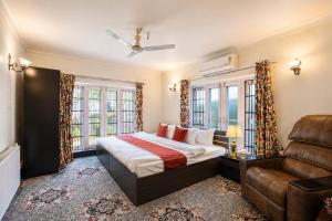 a bedroom with a bed and a couch and windows at Dar-e-Shafi in Srinagar