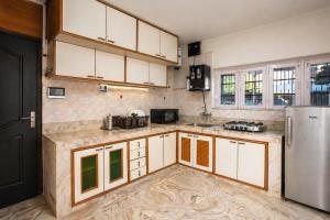 a kitchen with white cabinets and a stainless steel refrigerator at Dar-e-Shafi in Srinagar