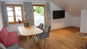 a living room with a table and chairs and a television at Ferienwohnung Anna in Bad Kohlgrub