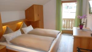 a bed sitting in a room with a window at Ferienwohnung Anna in Bad Kohlgrub