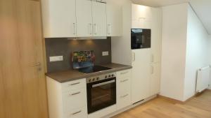 a kitchen with white cabinets and a stove top oven at Ferienwohnung Anna in Bad Kohlgrub