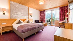 a hotel room with a bed and a balcony at Hotel Goldene Rose in Reutte