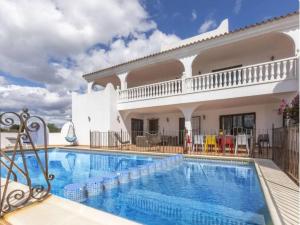 a villa with a swimming pool in front of a house at Finca Azahar in Sant Jordi
