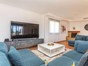 a living room with blue couches and a tv at Finca Azahar in Sant Jordi