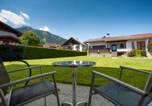 a patio with a table and chairs in a yard at Hotel Goldene Rose in Reutte
