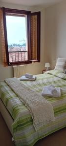 a bedroom with two beds and a window with a view at Maisonette Agata in Toscolano Maderno