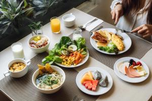 a table with plates of food on it at Movenpick Suriwongse Hotel Chiang Mai in Chiang Mai