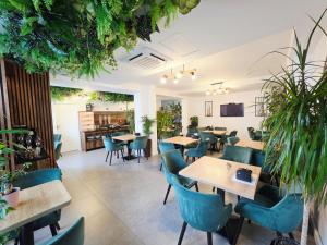 a restaurant with tables and chairs and plants at Hotel B4 in Oradea
