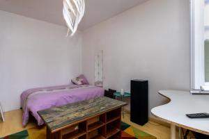 a bedroom with a bed and a table in it at Belle Maison Basque à Bardos Clim in Bardos