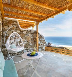a patio with a table and chairs and the ocean at Sugar Blue in Mikonos