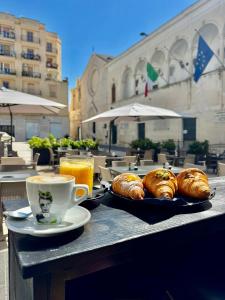 a table with two plates of pastries and a cup of coffee at Dimora in Cortile in Manfredonia