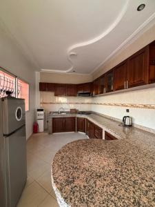 a kitchen with wooden cabinets and a stainless steel refrigerator at Apartment with pool next to the ocean in Agadir nʼ Aït Sa
