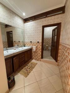 a large bathroom with two sinks and a shower at Apartment with pool next to the ocean in Agadir nʼ Aït Sa