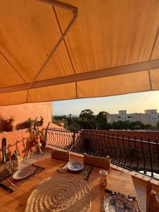a patio with a wooden table and a large umbrella at Apartment with pool next to the ocean in Agadir nʼ Aït Sa +10 photos