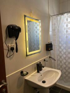 a bathroom with a sink and a mirror and a shower at Lana's Studio in King Abdullah Economic City