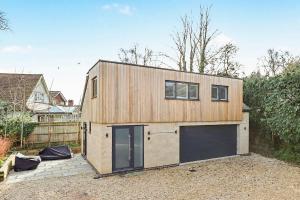 a small wooden house with a garage at Stay in Style, Two Bed! in Appleford