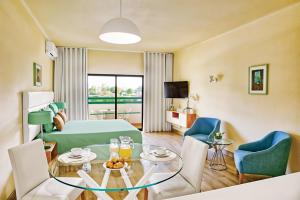 a room with a bed and a table and chairs at Ondamar Hotel Apartamentos in Albufeira