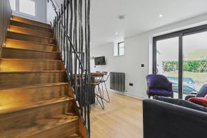 a staircase in a living room with a table and chairs at Stay in Style, Two Bed! in Appleford