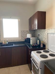 a kitchen with a white stove top oven next to a window at Lana's Studio in King Abdullah Economic City +8 photos