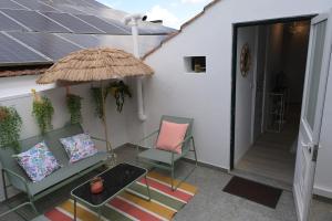 a patio with two chairs and an umbrella at Vila Real Center Terrace in Vila Real