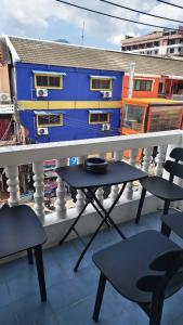 a balcony with a table and chairs and a blue building at jdreamboxhostelpatong in Patong Beach