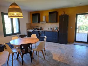 a kitchen with a wooden table and chairs in a kitchen at Maquis in Mialet