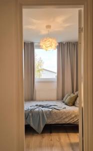 a bed in a room with a window and a chandelier at Hiiu korter Kärdlas in Kärdla
