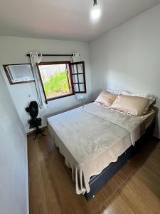 a bedroom with a large bed with a window at Rancho Alto do Valle in Paty do Alferes