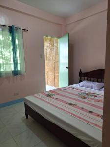 a bedroom with a large bed and a window at Ngak-Ngak Beach Resort in Calatrava