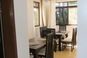 a dining room with tables and chairs and a window at Residence Six Sigma in Entebbe